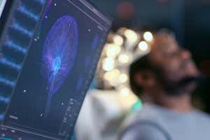 Man Wearing Brainwave Scanning Headset Sits in a Chair with Closed Eyes