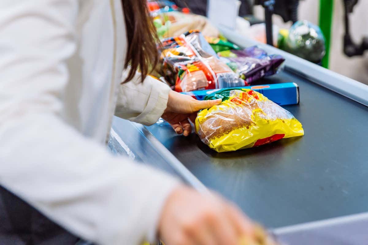 woman put products on the line near cashbox. grocery shopping concept