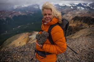 Kris Tompkins holds up a heartshaped rock during her hike up the mountain range in Patagonia, Chile. (Jimmy Chin)